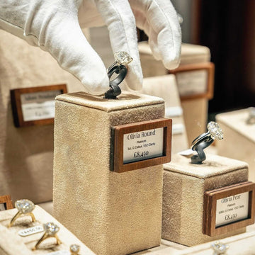 Brown wooden price holders used to display prices next to jewelry in a glass showcase