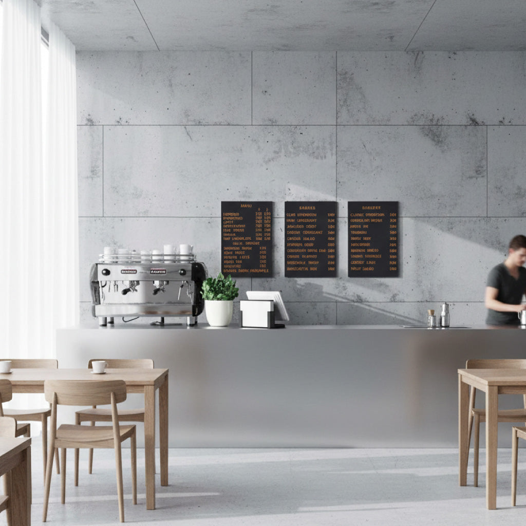 Wall-mounted magnetic menu board with wooden letters in a Scandinavian-style coffee shop setting.