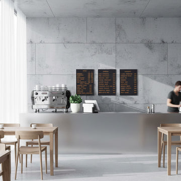 Wall-mounted magnetic menu board with wooden letters in a Scandinavian-style coffee shop setting.