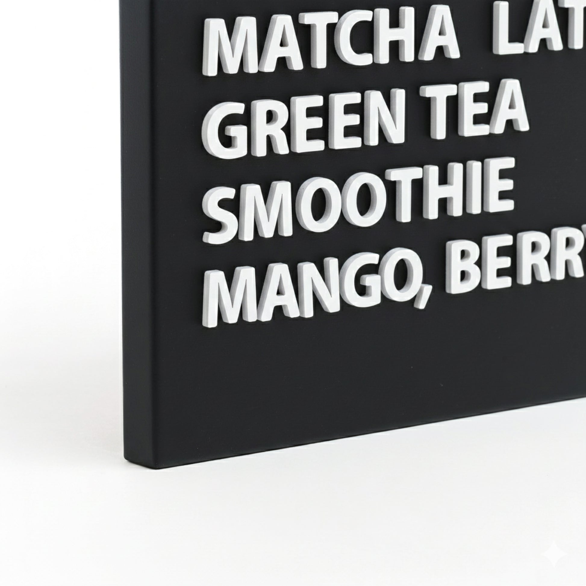 Close-up of white wooden magnetic letters arranged on a black menu board.